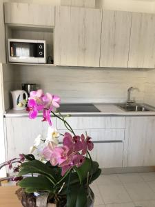 una cocina con un jarrón de flores sobre una mesa en Casa Eva, en Bibione