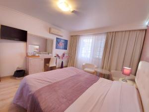 a bedroom with a bed and a table and chairs at VILA FORMOSA AL-Estabelecimento de Hospedagem,Quartos-Rooms in Monte Gordo