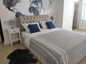 - une chambre avec un grand lit et des oreillers bleus dans l'établissement Dom Rabinovicha, à Odessa