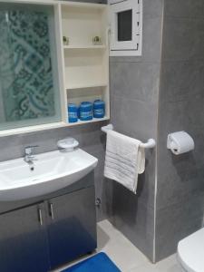 ein Bad mit einem Waschbecken und einem Spiegel in der Unterkunft Appartement résidence Atlantic 1 in Kenitra