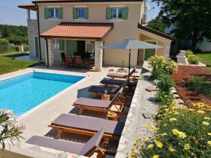 a villa with a swimming pool and a house at VILLA STELLA JURICANI in Umag