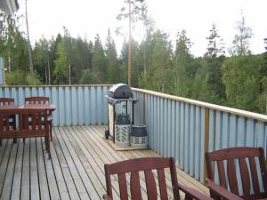 a deck with two benches and a grill on it at Espoo Sun Cottages in Espoo