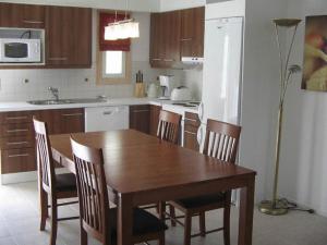 - une cuisine avec une table à manger en bois et des chaises dans l'établissement Espoo Sun Cottages, à Espoo