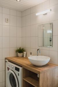 a bathroom with a sink and a washing machine at Kuressaare Turu Apartment in Kuressaare +10 photos