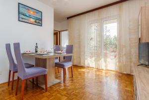 a dining room with a table and chairs and a television at Apartment Dragica in Krk