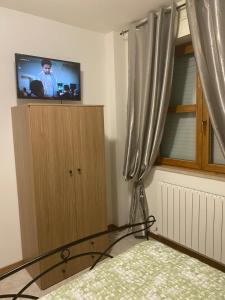 sypialnia z łóżkiem i telewizorem w oknie w obiekcie La Casa al Bacio w mieście Perugia