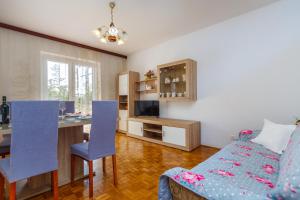 a living room with a bed and a desk and a kitchen at Apartment Dragica in Krk