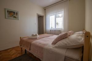 a bedroom with a bed with two stuffed animals on it at Apartment Blašković in Novigrad Dalmatia