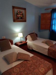 a bedroom with two beds and a lamp and a rug at L'Ermita Casa Ripo in Vall dʼAlba