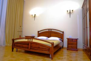 Araks Hotel Complex في غيومري: غرفة نوم بسرير خشبي وموقف ليلي