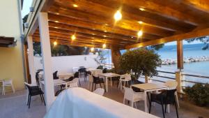 un restaurante con mesas y sillas y vistas al océano en Apartments & Rooms Baltazar, en Podstrana