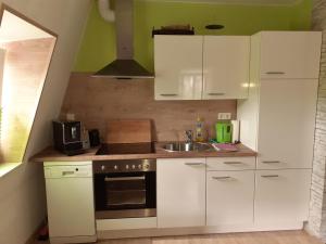 eine Küche mit weißen Schränken und einem Waschbecken in der Unterkunft Ferienwohnung Röschen in Bernkastel-Kues