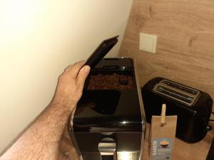 Eine Person steckt Essen in einen Toaster. in der Unterkunft Ferienwohnung Röschen in Bernkastel-Kues