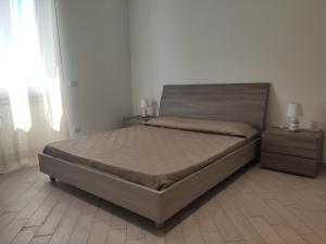 Fiumicino Dream & Fly 2 في فيوميتشينو: غرفة نوم مع سرير مع مواقف ليلتين ومصباحين