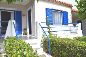 a house with blue shutters and stairs in front at Panorama Apartments in Methoni