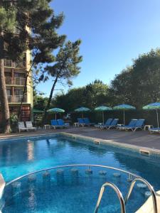 a swimming pool at a hotel with chairs and umbrellas at Hotel Nimfa-Rusalka in Sunny Beach