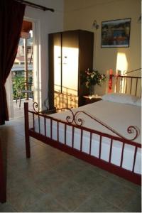 a bedroom with a large bed and a balcony at Sillelis Rooms in Rovies