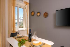 a dining room with a table and a tv at AlPe Mar in Rovinj