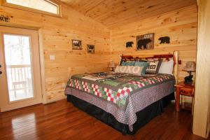 1 dormitorio con 1 cama en una cabaña de madera en Endless Mountain Dreams en Gatlinburg