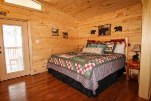 a bedroom with a bed in a wooden cabin at Endless Mountain Dreams in Gatlinburg