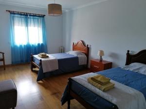 a bedroom with two beds and a table and a window at Arquinha Apartment in Ponta Delgada