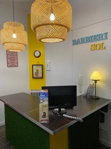 einen Schreibtisch mit einem Computermonitor darüber in der Unterkunft Barbieri Sol Hostel in Madrid