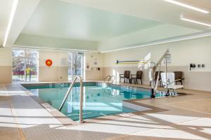 a large swimming pool with blue water in a building at Comfort Inn & Suites in Goderich