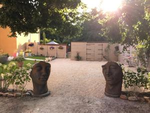 two headulptures of heads are sitting in a yard at Mas Le Nathakassou in Cabannes