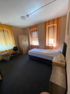 a bedroom with a bed and a desk and windows at Hotel-Gasthof "Alter Ritter" in Rothenburg ob der Tauber