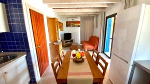 een keuken met een houten tafel met stoelen en een wastafel bij CAN DAMIA 3 in Cala Saona