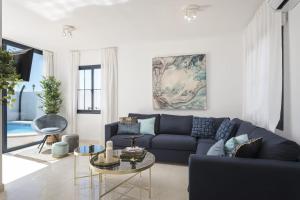 a living room with a blue couch and a table at Villa Roble in Yaiza