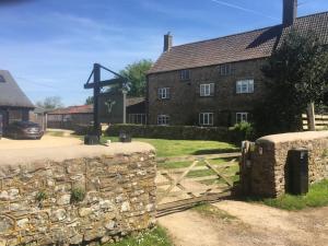 a stone wall next to a building with a gate at Russet in Yate