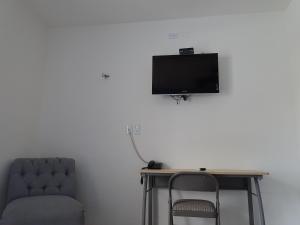 a desk with a chair and a television on a wall at Hotel Villa Escondida Campeche in Campeche