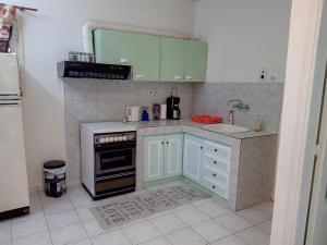 a small kitchen with green cabinets and a sink at Cozy house 2 in Vrachati