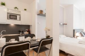 米兰米兰皇家套房 - 卡多纳中心公寓的一间厨房和一间带桌椅的餐厅