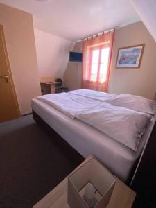 a bed in a bedroom with a box on the floor at Hotel-Gasthof "Alter Ritter" in Rothenburg ob der Tauber