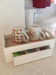 a drawer with two mugs on top of it at Les Landes De Mauchat in Saint-Martin-de-Fressengeas