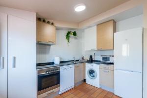 a kitchen with white appliances and a washer and dryer at Palacio Descalzos -Atico 3b- Parking incluido in Tudela