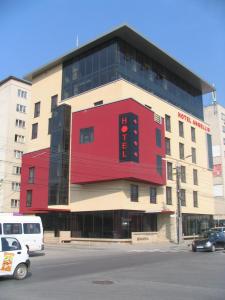 a large building with a red in a parking lot at Hotel Angellis in Timişoara