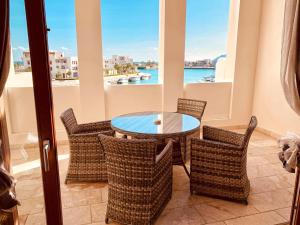 einen Tisch und Stühle auf einem Balkon mit Blick auf das Wasser in der Unterkunft Sifa Getaway in Muscat
