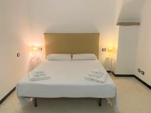 1 dormitorio con 1 cama con 2 toallas en Le case della Lizza - Casa Blu, en Levanto