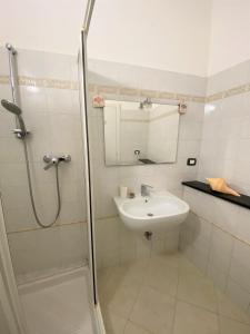 y baño blanco con lavabo y ducha. en Le case della Lizza - Casa Blu, en Levanto