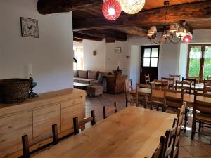 a room with a table and chairs and a couch at LA JARBELLE - Gîte et Spa in Les Orres