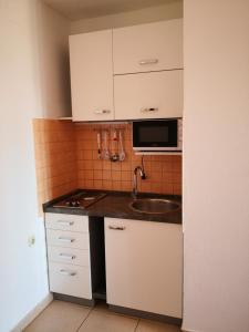 a small kitchen with a sink and a microwave at Apartment Plavia Biograd in Biograd na Moru