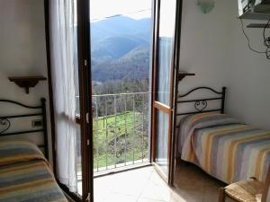 ベヴェリーノにあるAgriturismo Casalinoのベッド2台と大きな窓が備わる客室です。