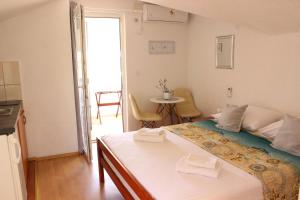 a bedroom with a bed and a table with chairs at Apartments Villa Arta in Murter