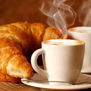 - une tasse de café et des croissants sur une table dans l'établissement Hotel Restaurante Salvadora, à Villena