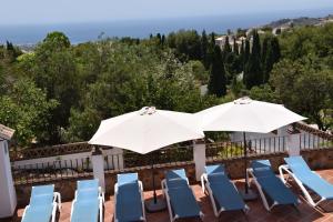 un gruppo di sedie e ombrelloni su un patio di Villa Pelae a Frigiliana