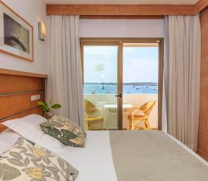 a bedroom with a bed and a view of the ocean at Hostal la Savina in La Savina