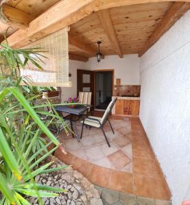 a patio with a table and chairs and a wooden ceiling at Apartments Villa Arta in Murter